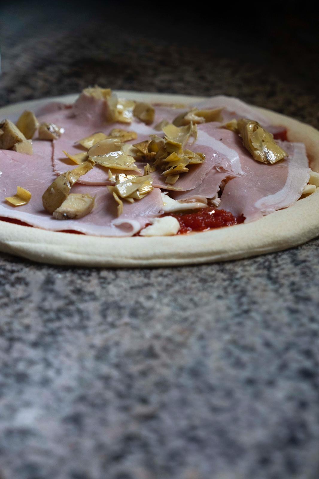 Pizza with ham and artichokes preparation at Kalura, Antwerp