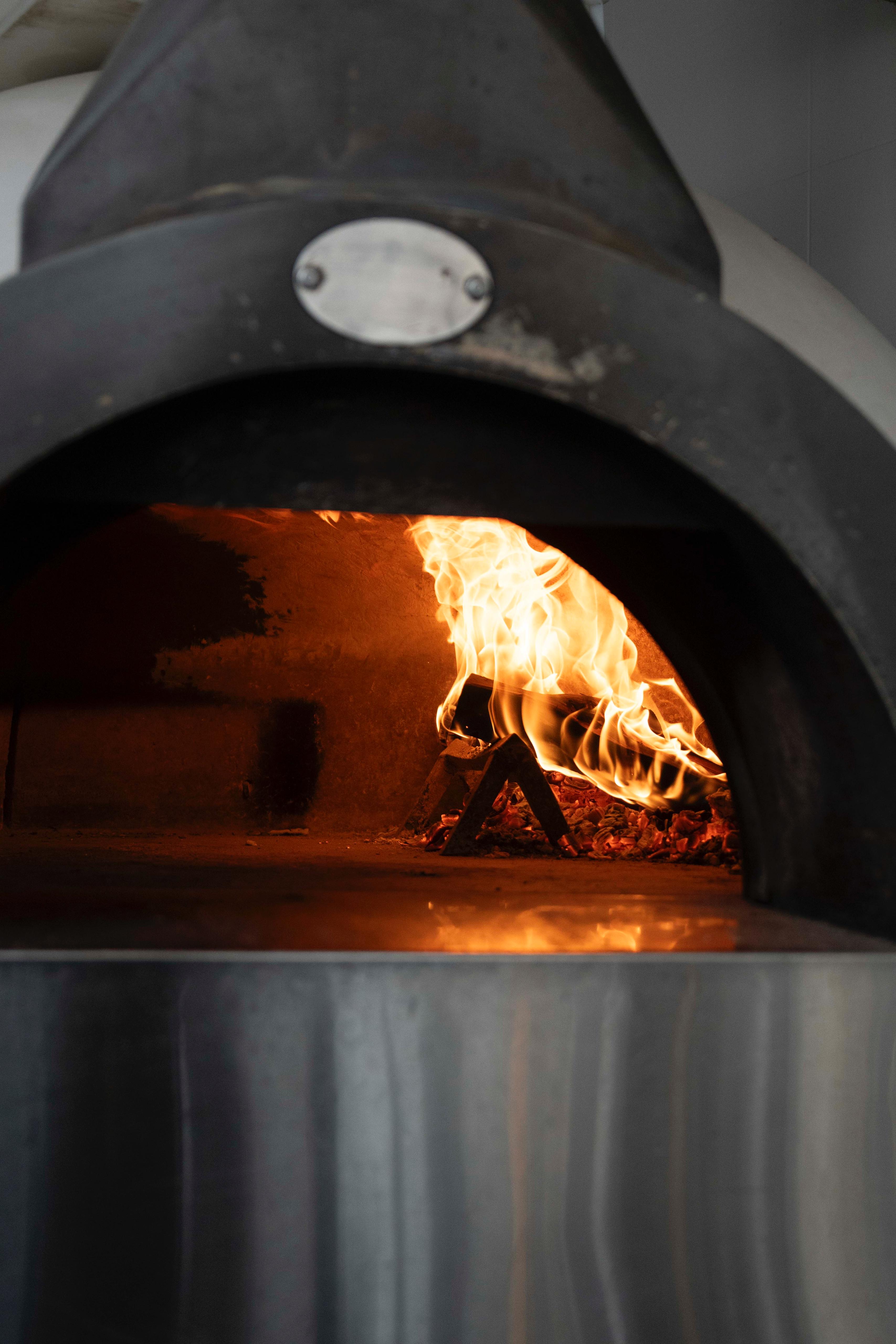 Wood-fired oven with flames at Kalura, Antwerp