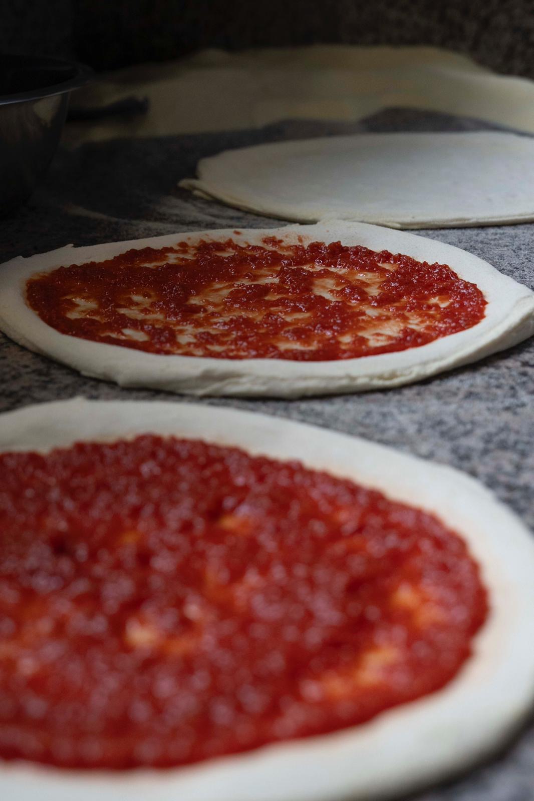 Pizza bases with tomato sauce at Kalura, Antwerp