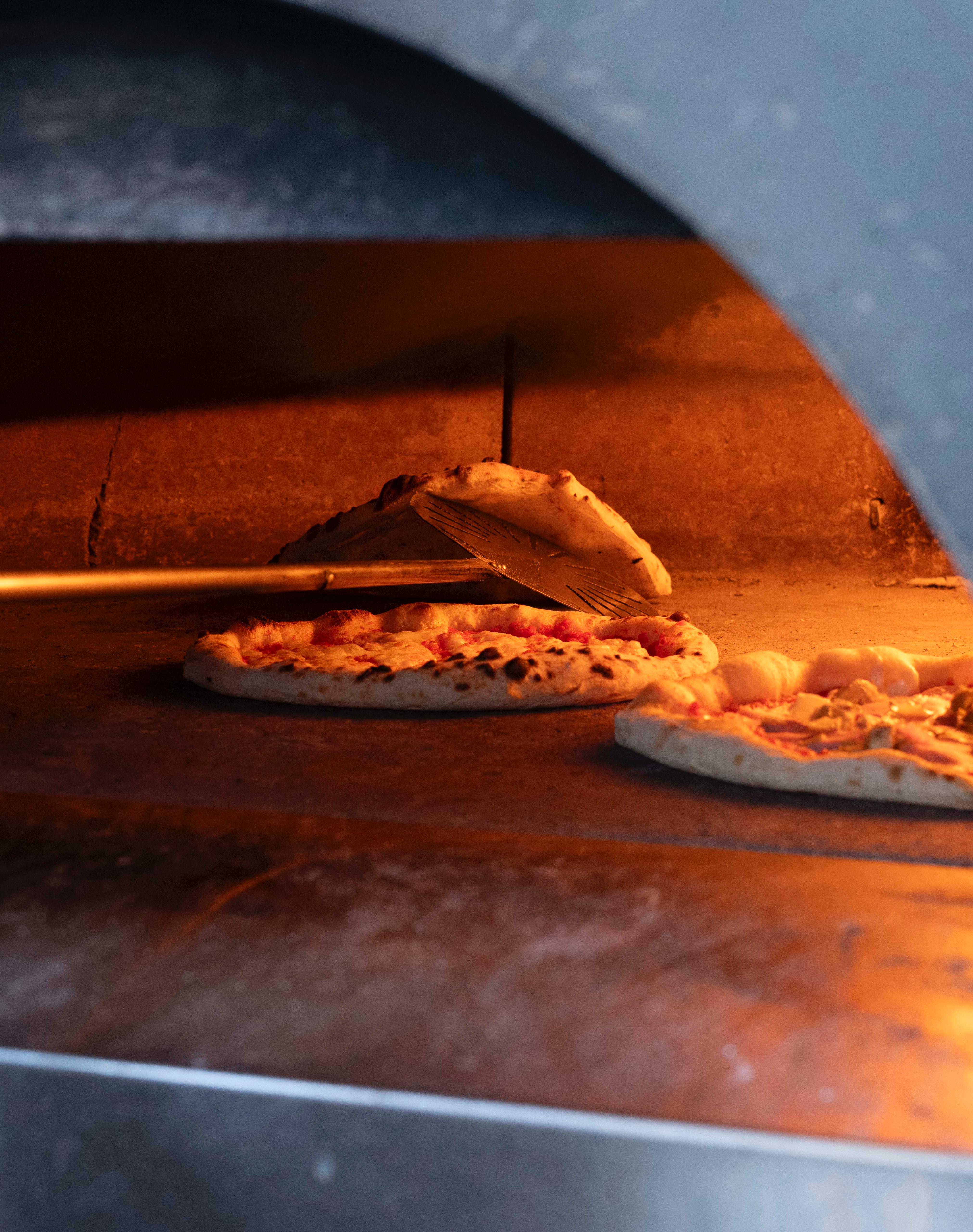 Turning pizza in the oven at Kalura, Antwerp