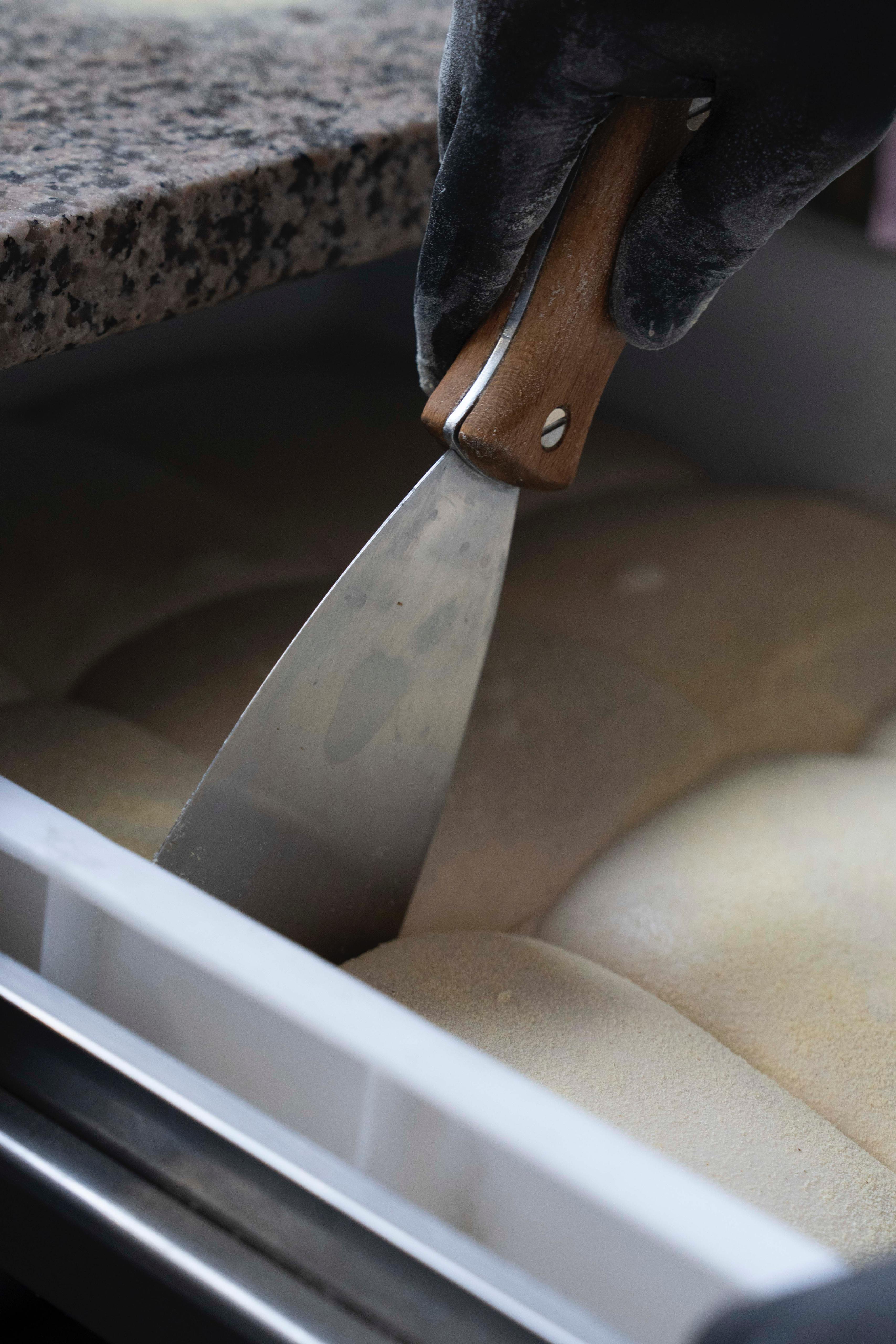 Cutting dough with a scraper at Kalura, Antwerp